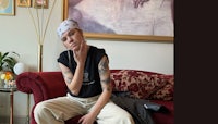 a woman sitting on a couch with tattoos