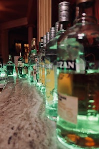 a row of liquor bottles on a marble counter