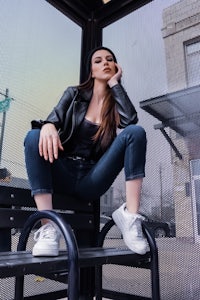 a woman sitting on a bench in a bus stop